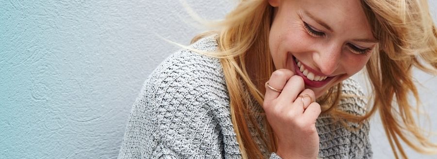 Quoi faire quand on est seul à la Saint-Valentin - Femme qui s's'amuse et rit seule - Blogue | Clinique de Psychologie Québec