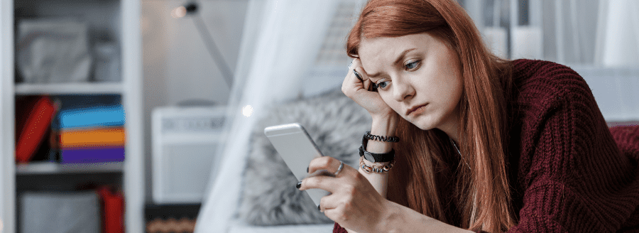 Jeune fille qui regarde son téléphone cellulaire - L'Impact d'Internet et des médias sociaux dans le développement de la sexualité des adolescents - Blogue | Clinique de Psychologie Québec