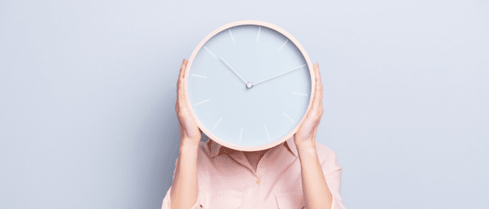 femme cachée derrière une horloge géante