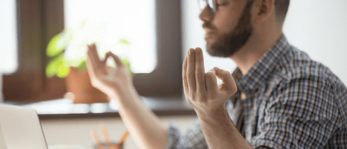 jeune homme zen assis à son bureau de travail