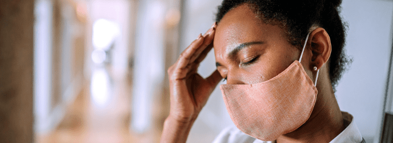 Femme portant un masque qui semble épuisée - Comment reconnaître les signes d'épuisement professionnel (burnout) - Blogue | Clinique de Psychologie Québec