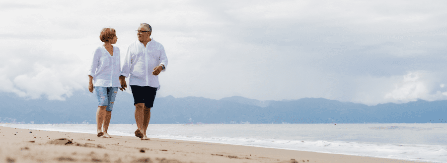 Couple se tenant la main en marchant sur la plage - Comment faire le bon choix en amour - Blogue | Clinique de Psychologie Québec