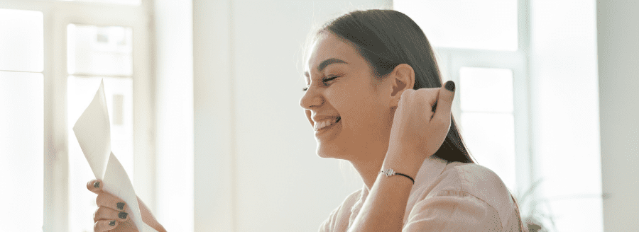 Femme heureuse tenant une lettre - Comment faire le bon choix en amour - Blogue | Clinique de Psychologie Québec