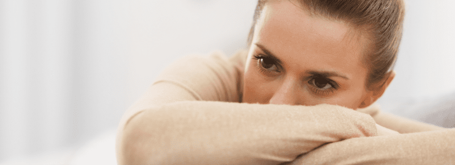 Femme avec la tête posée sur ses bras croisés - La violence psychologique, comment l'identifier et la combattre - Blogue | Clinique de Psychologie Québec
