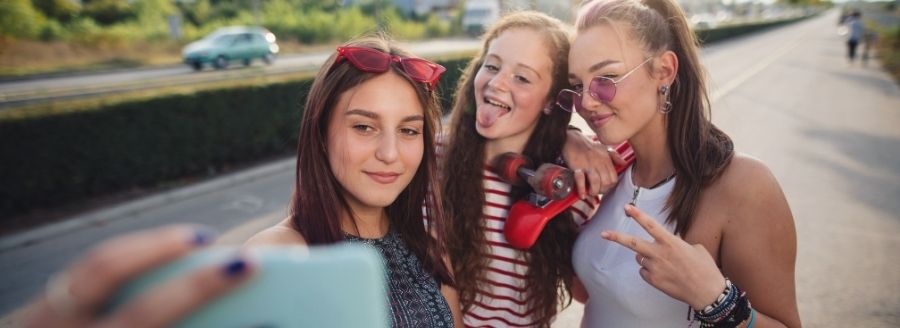 Jeunes filles qui prennent un selfie - L'impact d'Internet et des médias sociaux dans le développement de la sexualité chez les adolescents - Blogue | Clinique de Psychologie Québec