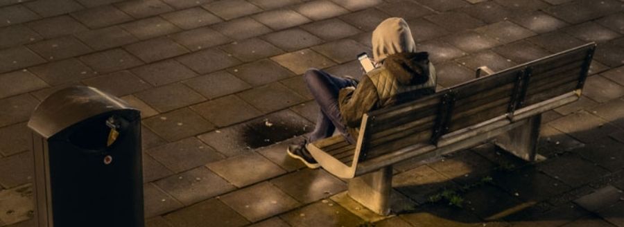 Homme dans un parc la nuit qui regarde son téléphone cellulaire - L'impact d'Internet et des médias sociaux dans le développement de la sexualité chez les adolescents - Blogue | Clinique de Psychologie Québec