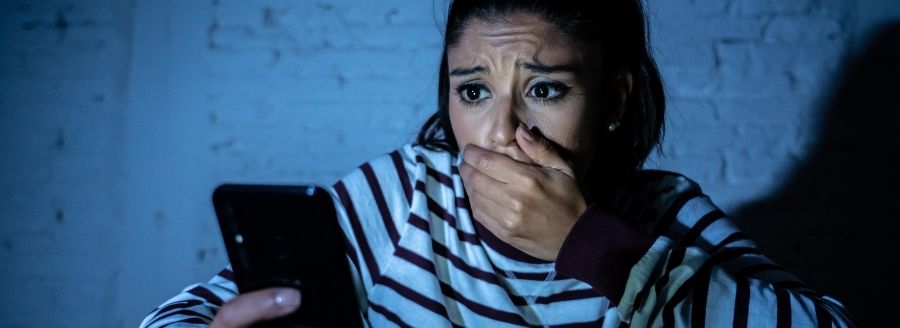 Jeune femme effrayée par ce qu'elle voit sur son cellulaire - L'impact d'Internet et des médias sociaux dans le développement de la sexualité chez les adolescents - Blogue | Clinique de Psychologie Québec