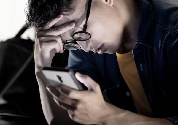 Adolescent déprimé qui regarde son cellulaire - L'impact d'Internet et des médias sociaux dans le développement de la sexualité chez les adolescents - Blogue | Clinique de Psychologie Québec