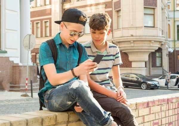 2 adolescents qui regardent un cellulaire - L'impact d'Internet et des médias sociaux dans le développement de la sexualité chez les adolescents - Blogue | Clinique de Psychologie Québec