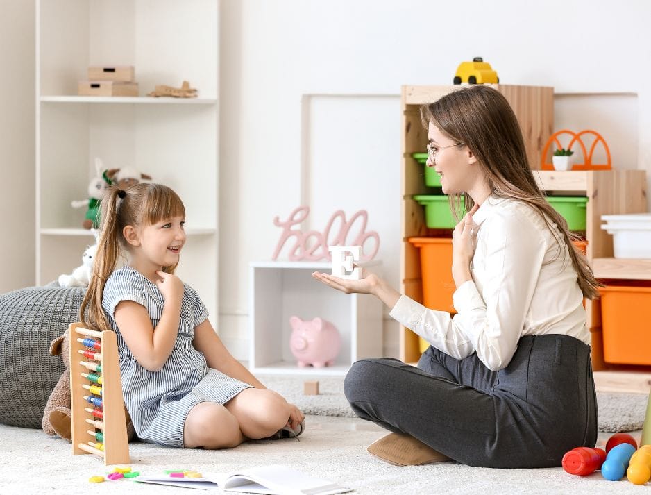 jeune femme orthophoniste en séance d'évaluation avec un enfant